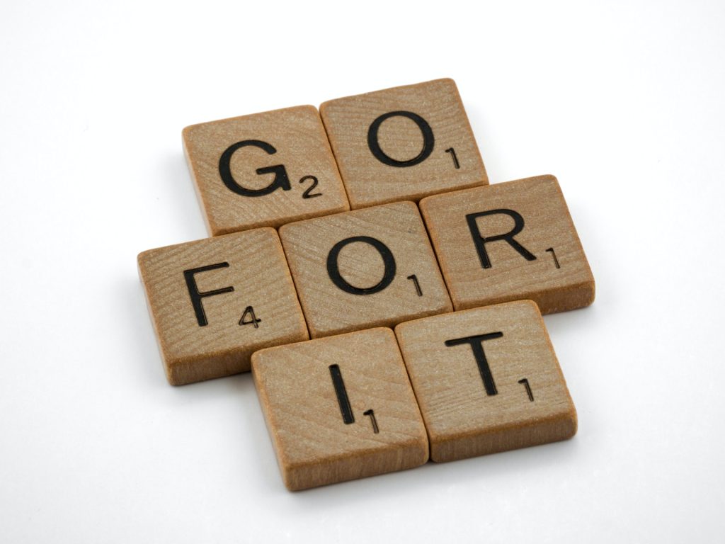 Scrabble pieces arranged to form the sentence "Go for it". Overcoming challenges require taking action. Identify and confront your challenges.