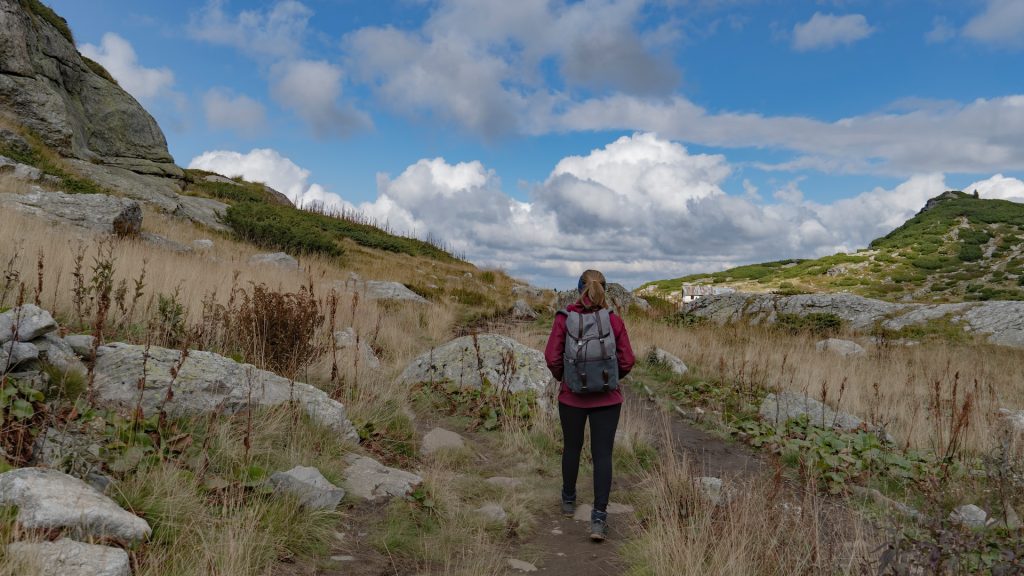 Lady walks a rocky path, overcoming challenges and obstacles.